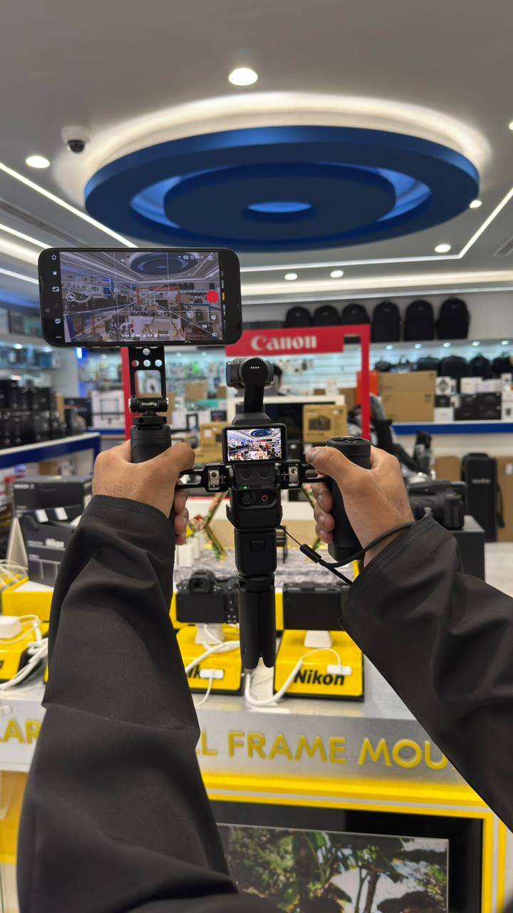 SmallRig Creator Rig for DJI Osmo Pocket 3 held in two hands with phone monitor at SkyOrbits Oman